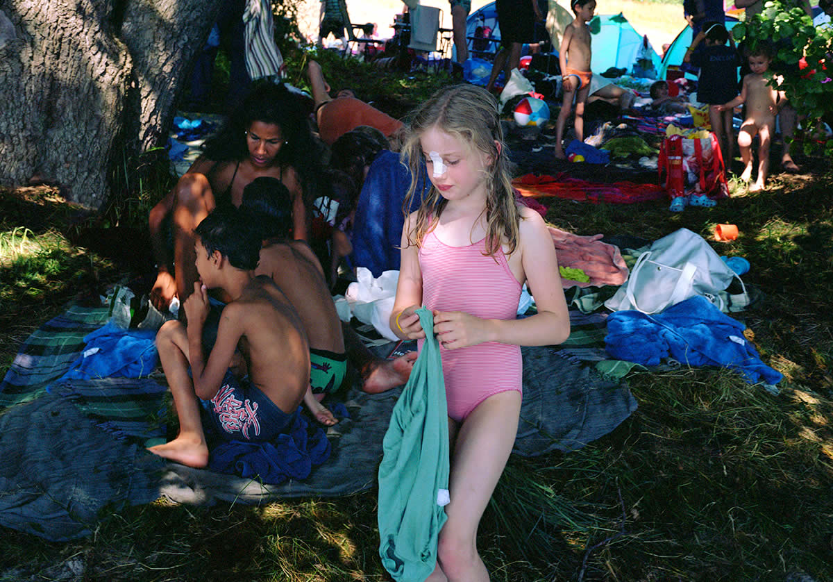 Girl in pink bathing suits with children in bathing suits behind her