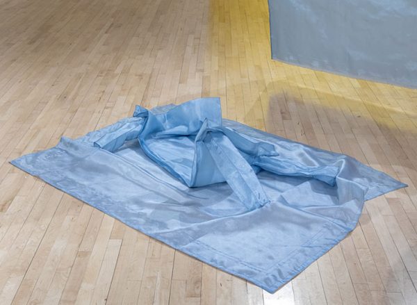 Blue translucent fabric on a light wooden floor.